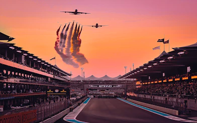 Airplanes flying over Yas Marina Circuit at sunset during Abu Dhabi Grand Prix.