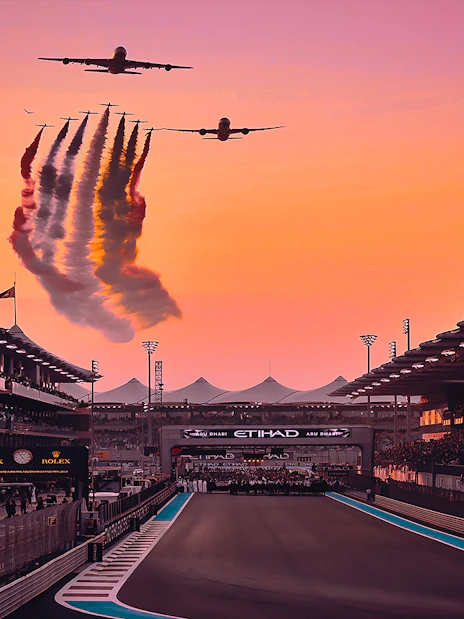 Airplanes flying over Yas Marina Circuit at sunset during Abu Dhabi Grand Prix.