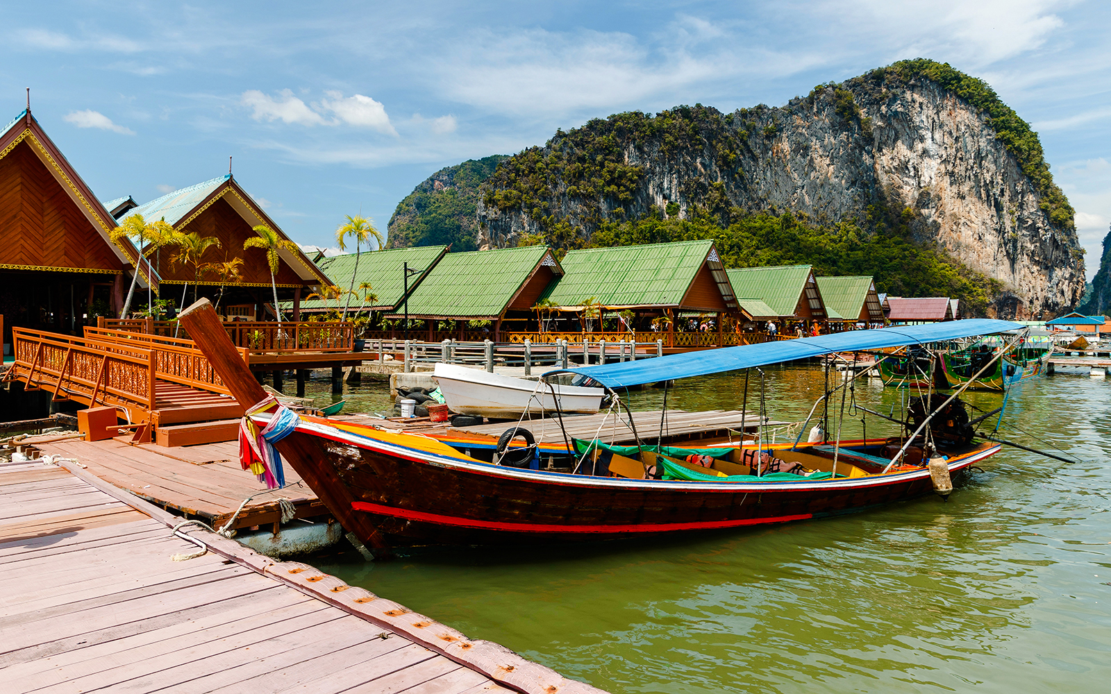 Ko Panyi stilt houses and longtail boat in Phang Nga Bay, Thailand.
