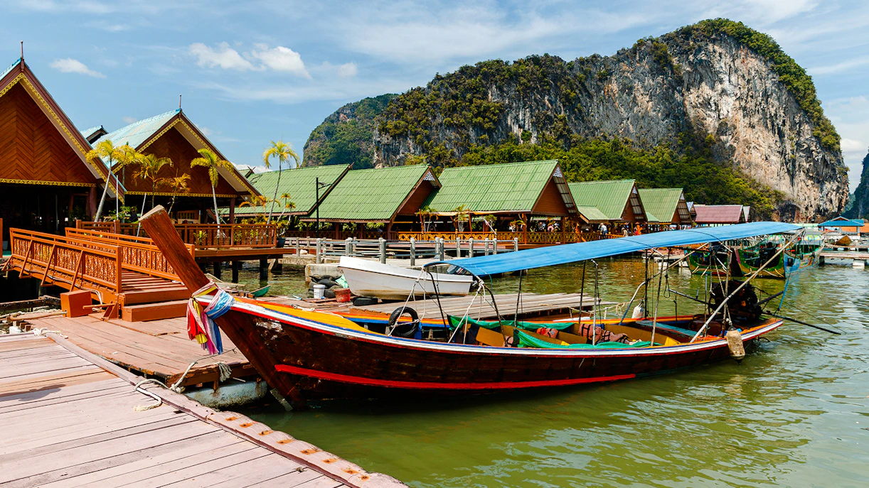 Ko Panyi stilt houses and longtail boat in Phang Nga Bay, Thailand.