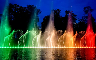 Fountains illuminated in vibrant colors at the Palace of Versailles show.