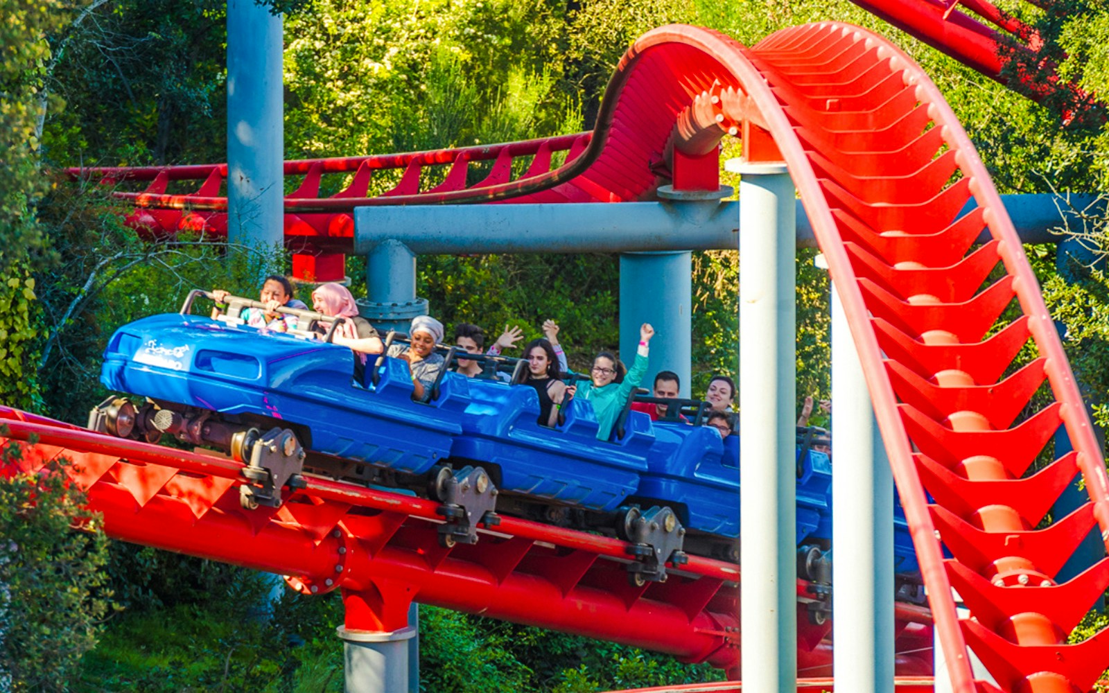 Roller coaster ride at Muntanya Russa with passengers enjoying the thrill.