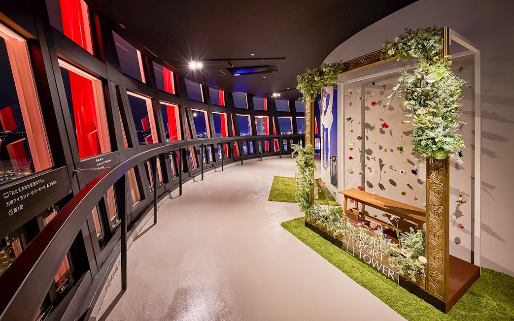 Kobe Port Tower interior with panoramic windows and floral display.
