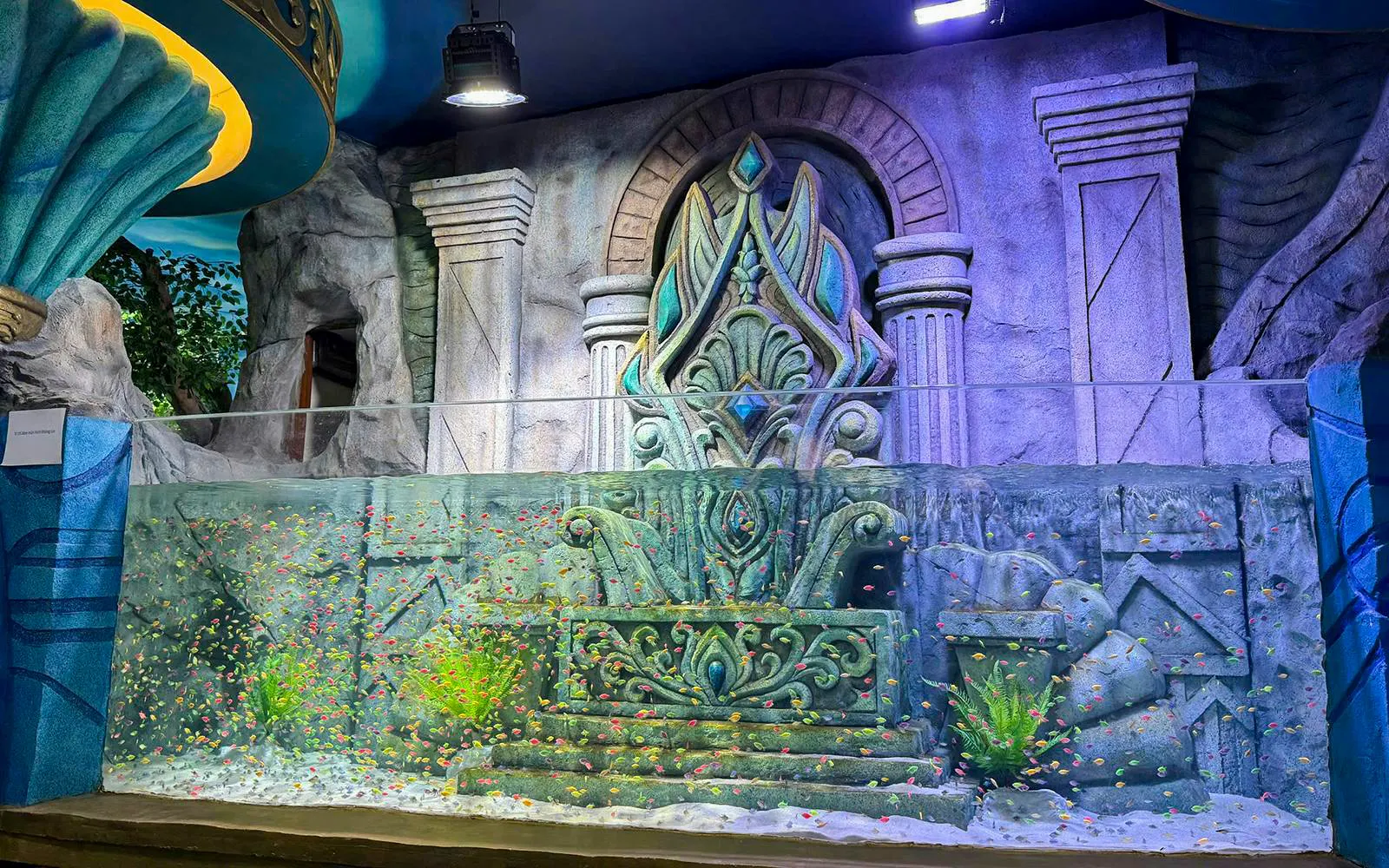 Vinwonders Phu Quoc Theme Park aquarium with ornate stone backdrop and colorful fish.