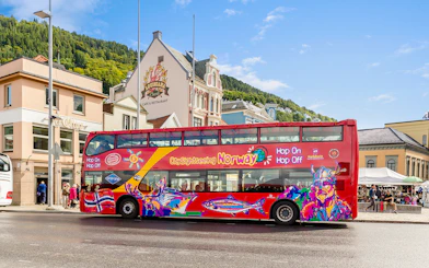 Bergen city sightseeing bus with colorful design parked near historic buildings.