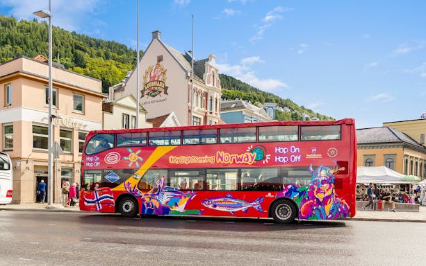 Bergen city sightseeing bus with colorful design parked near historic buildings.