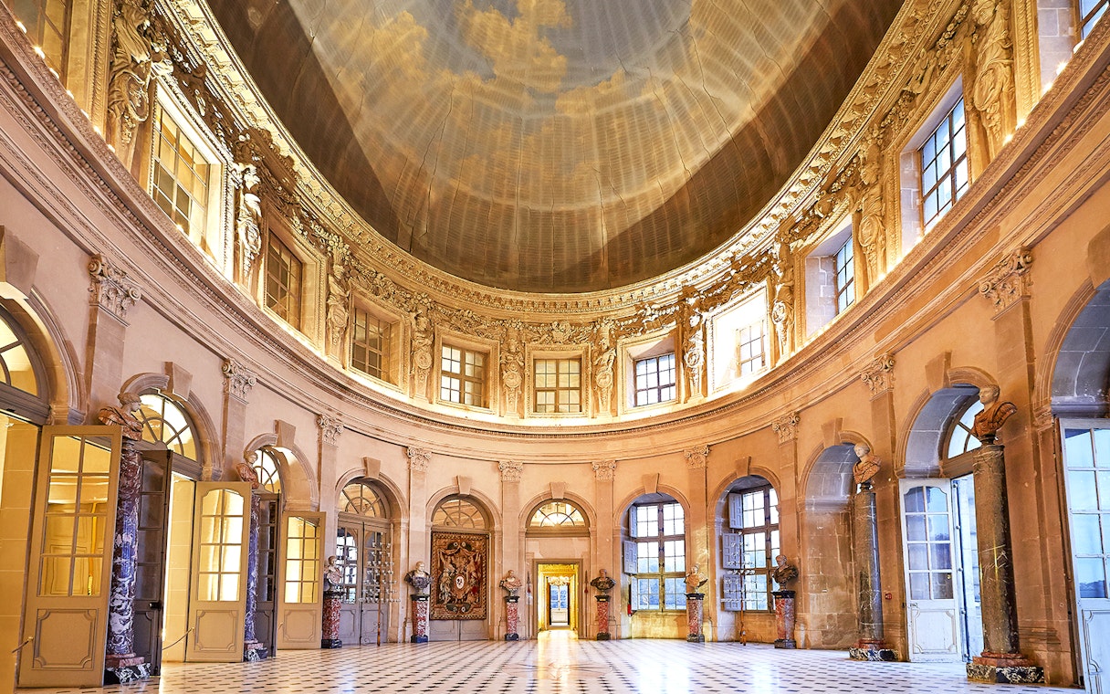Vaux-le-Vicomte Castle interior with ornate dome and marble columns.