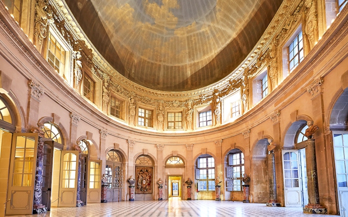 Vaux-le-Vicomte Castle interior with ornate dome and marble columns.