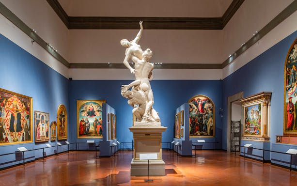 Statue and paintings in Academia Gallery, Florence, with skip-the-line ticket option.