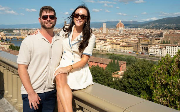 Couple enjoying a Florence tour with a view of the city and the Duomo in the background.