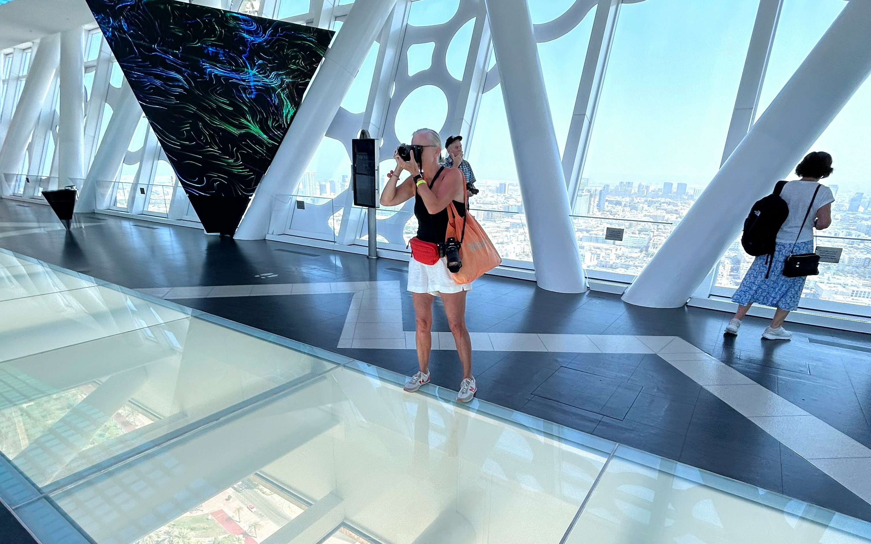 Person photographing Dubai skyline from inside Dubai Frame.