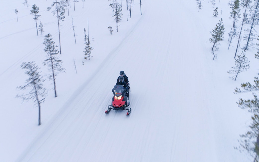 Snowmobile ride on frozen lake in winter, Lapland.
