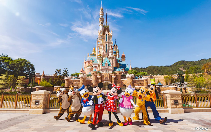 Disney characters in front of castle at Disneyland Hong Kong.