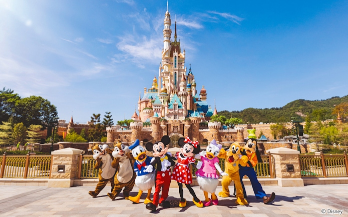 Disney characters in front of castle at Disneyland Hong Kong.