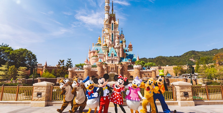 Disney characters in front of castle at Disneyland Hong Kong.