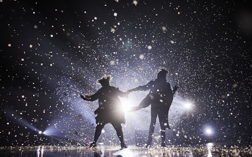 Performers on stage at Cirque du Soleil: Alegría in Seville, surrounded by confetti and lights.