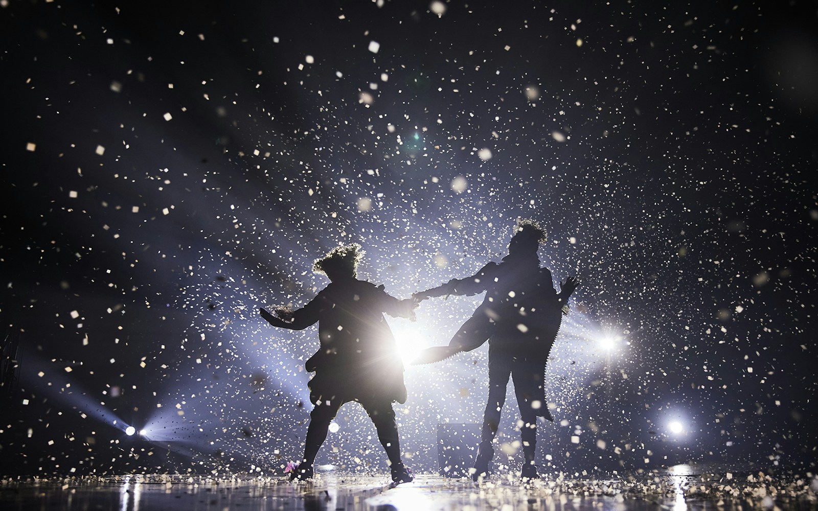 Performers on stage at Cirque du Soleil: Alegría in Seville, surrounded by confetti and lights.
