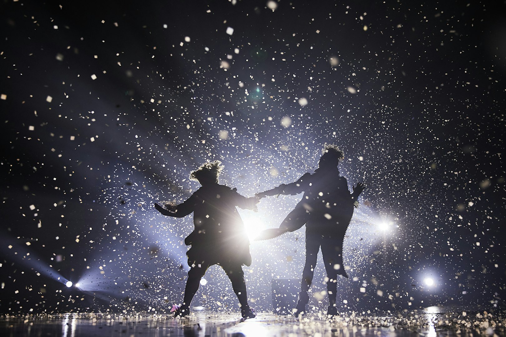 Performers on stage at Cirque du Soleil: Alegría in Seville, surrounded by confetti and lights.