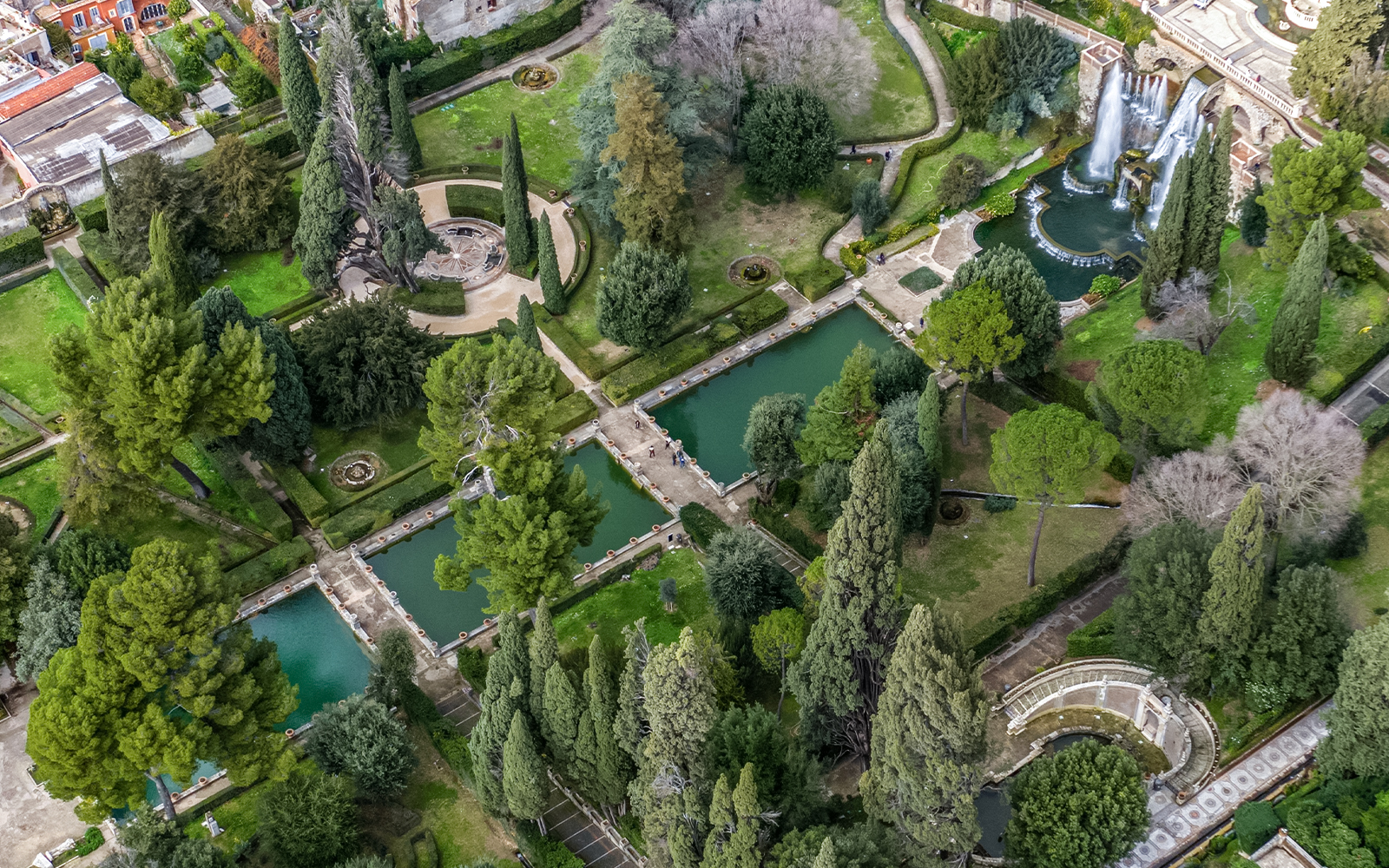 Aerial view of Villa d'Este gardens in Tivoli, Italy, featuring fountains and symmetrical pathways.