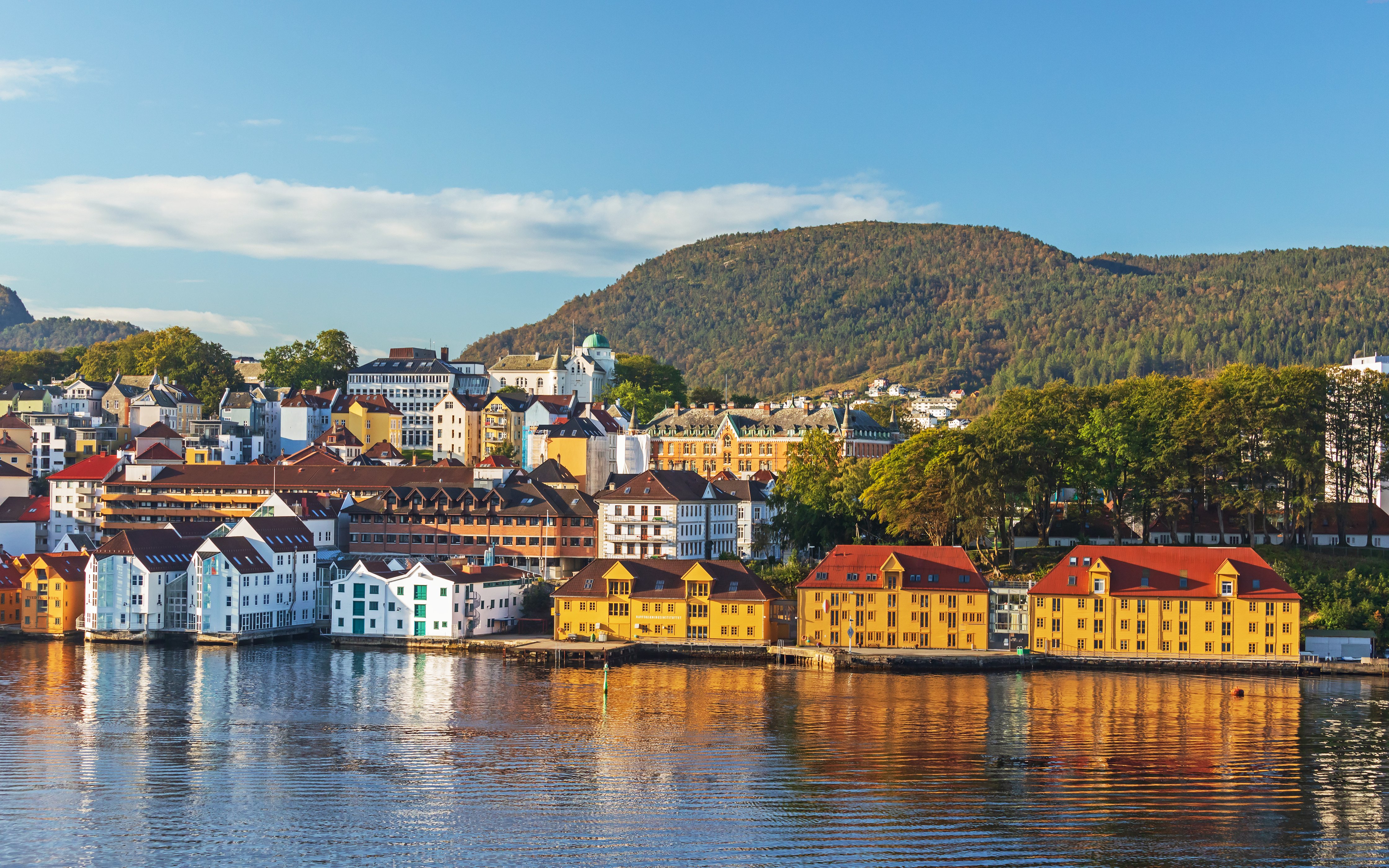 Colorful houses reflecting in the water on Nordnes Peninsula, Bergen, Norway, in morning light.