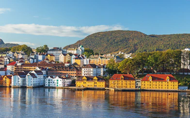 Colorful houses reflecting in the water on Nordnes Peninsula, Bergen, Norway, in morning light.