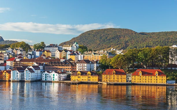 Colorful houses reflecting in the water on Nordnes Peninsula, Bergen, Norway, in morning light.