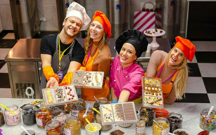 Participants in Vienna chocolate workshop displaying decorated chocolate bars.