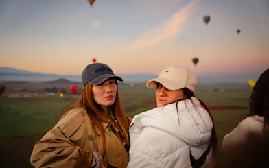 Women enjoying hot air balloon flight over Marrakech at sunrise.
