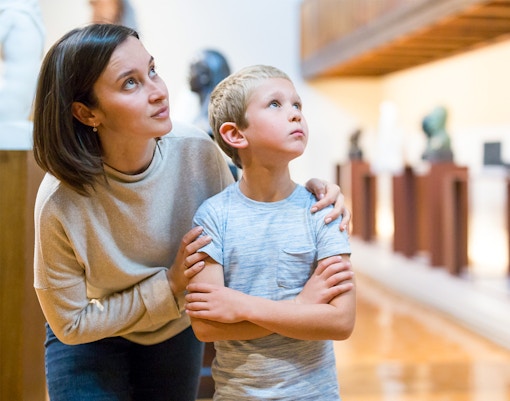 woman and child observing artefacts inside museum