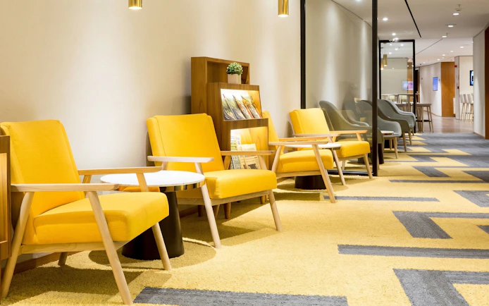 Seating area with yellow chairs at Plaza Premium Lounge, Rio de Janeiro International Airport, T2 Arrivals.