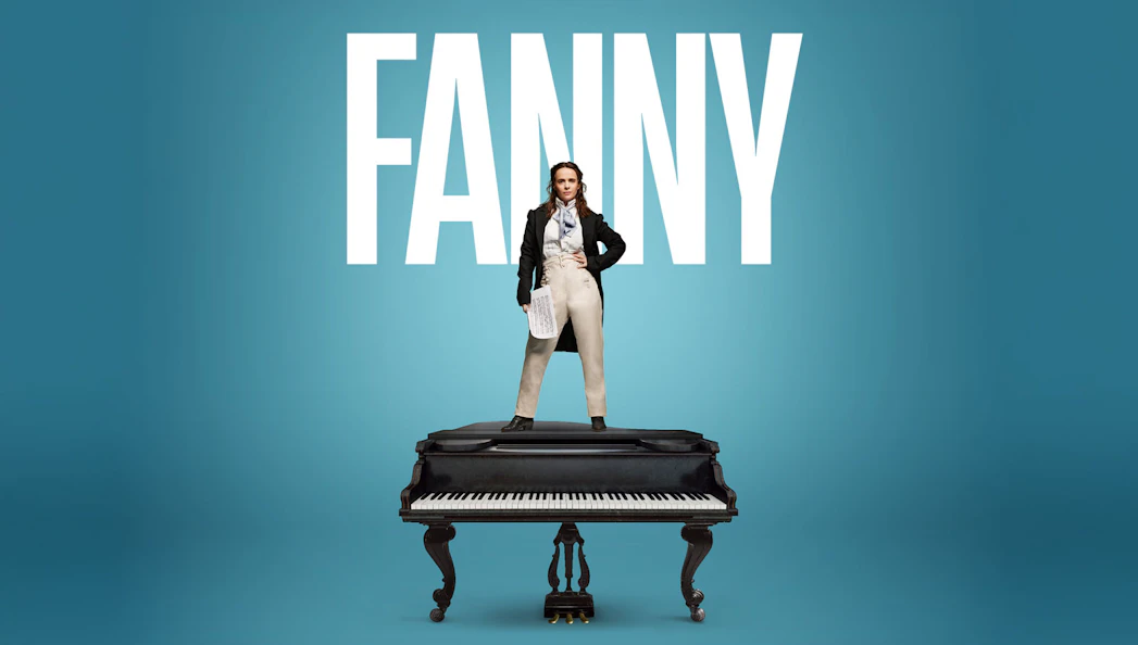 Performer standing on a grand piano in London theater.