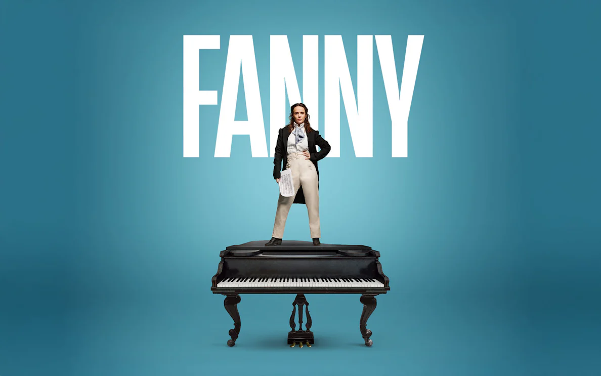 Performer standing on a grand piano in London theater.