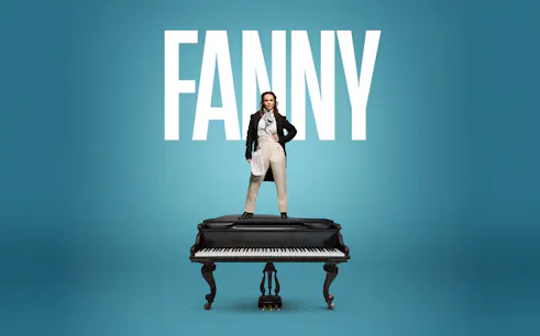 Performer standing on a grand piano in London theater.