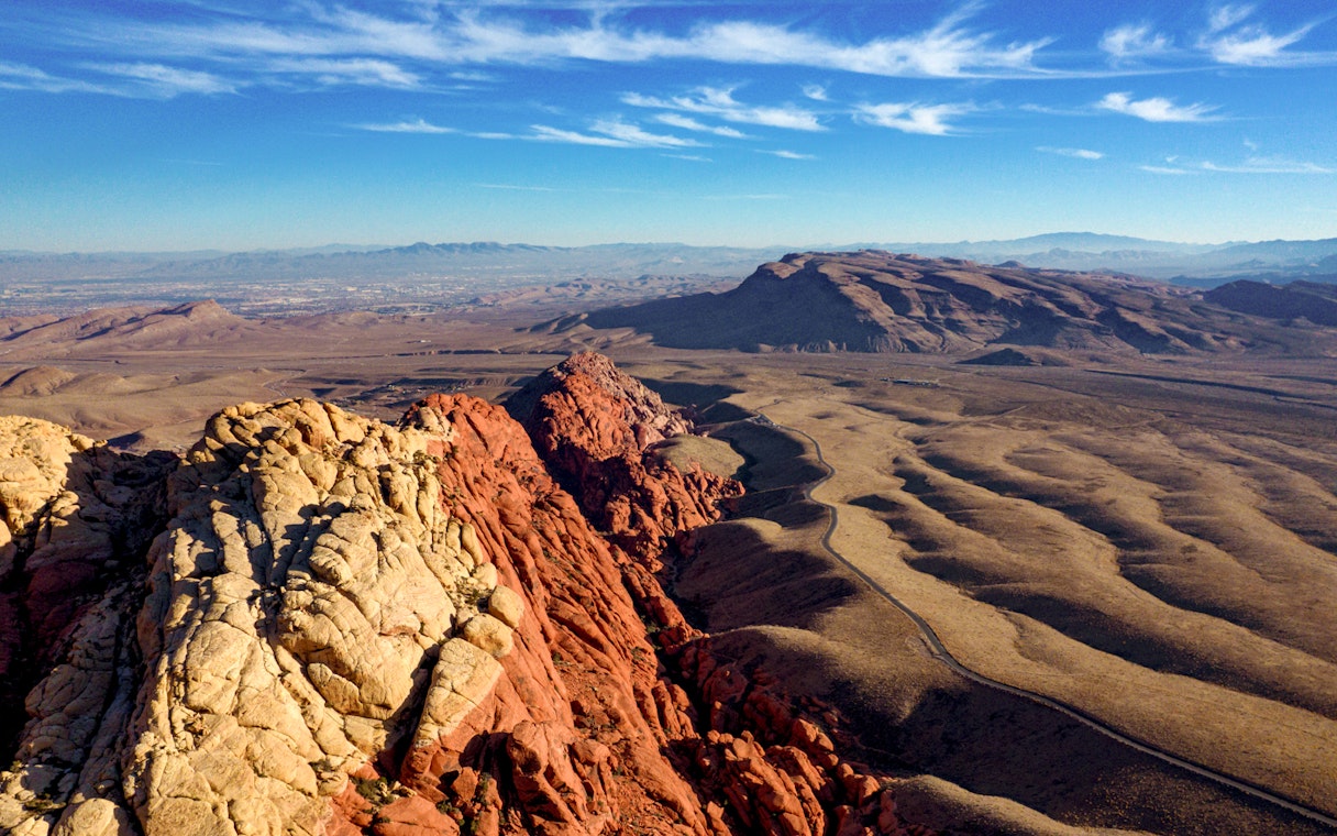 Red Rock Canyon landscape with red and beige rock formations under a blue sky.