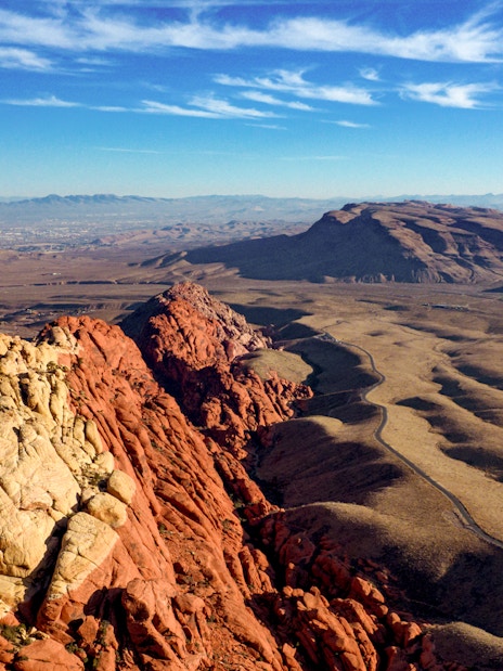 Red Rock Canyon landscape with red and beige rock formations under a blue sky.