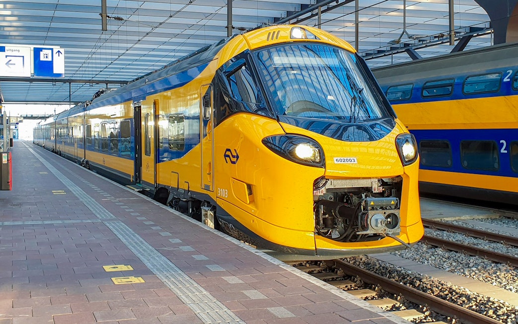 NS train at Schiphol Airport platform, ready for departure.