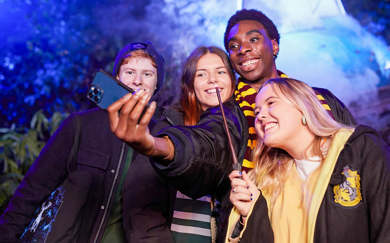 Group taking a selfie with wands at Harry Potter: A Forbidden Forest Experience.