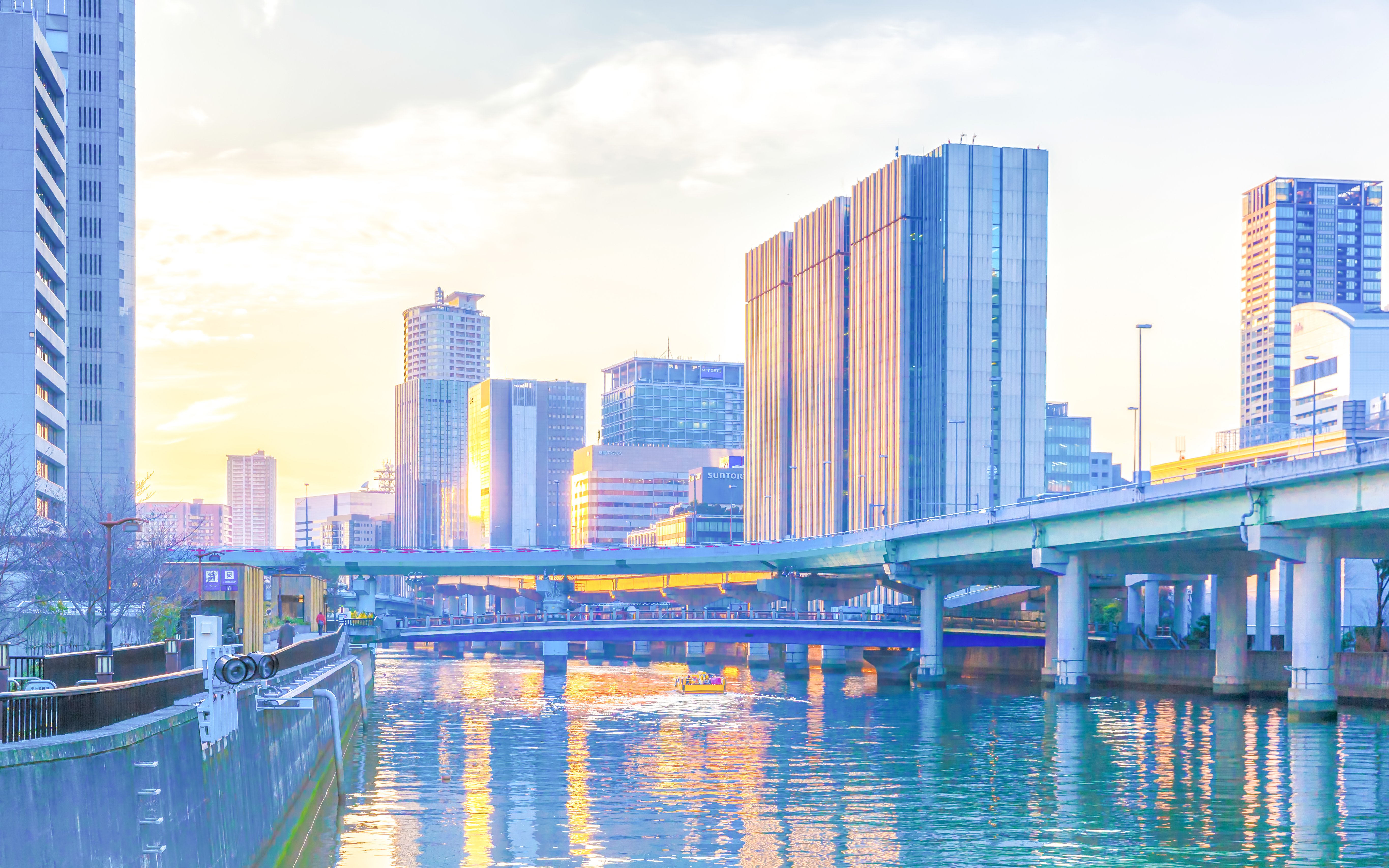 Cityscape with river and boat under bridges during sunset on a night river cruise.