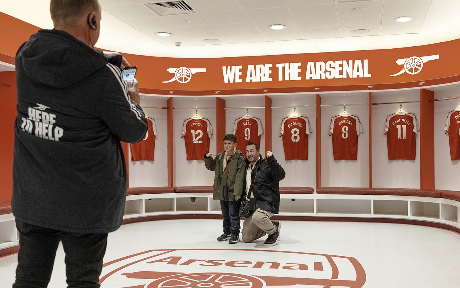Visitors posing in the Arsenal dressing room at Emirates Stadium, London.