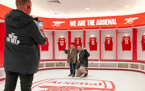 Visitors posing in the Arsenal dressing room at Emirates Stadium, London.