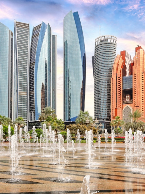 Etihad Towers and fountains in Abu Dhabi at sunset.