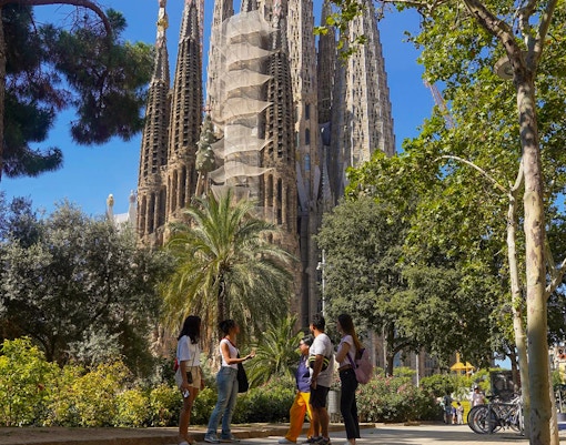 Tour group near Sagrada Familia in Barcelona, surrounded by trees.