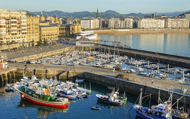 San Sebastian harbor with boats and cityscape, viewed from the Gipuzkoa coast.