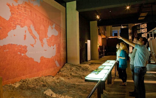 Visitors observing a historical map exhibit at Pont du Gard Museum.