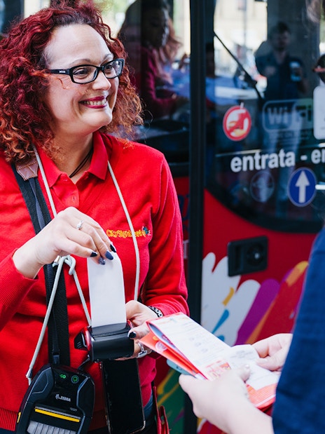 Bus staff assisting customer with ticketing.