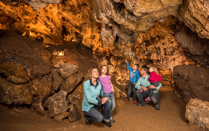 Family exploring stalactites in Historic Fairy Caves at Glenwood Caverns Adventure Park.