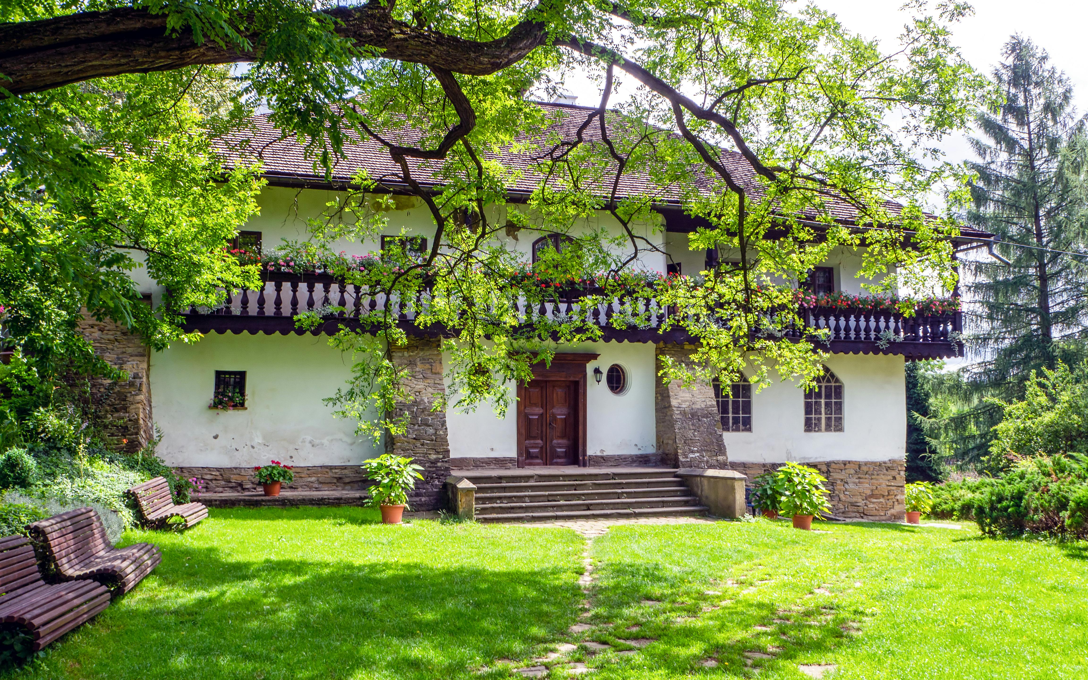 Manor house with stone steps and lush garden in Stryszow, Poland.