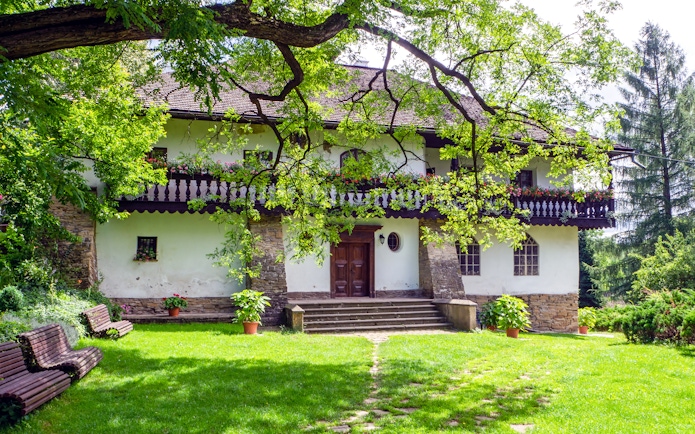 Manor house with stone steps and lush garden in Stryszow, Poland.