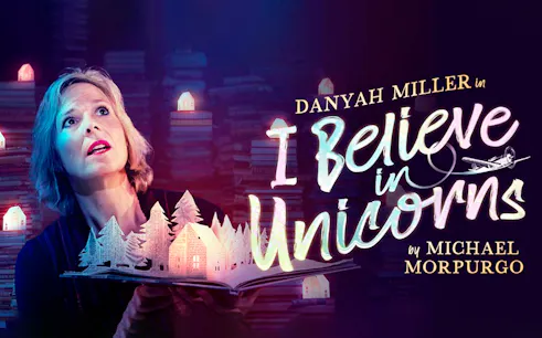 Person holding an open book with paper cut-out trees and houses, "I Believe In Unicorns" text.