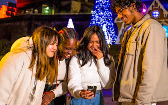 Group enjoying Niagara Festival of Lights Tour with illuminated trees in background.